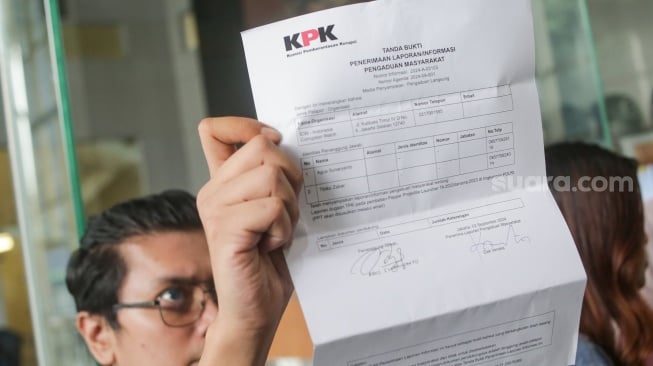 Sejumlah aktivis dari Koalisi Masyarakat Sipil untuk Reformasi Kepolisian menunjukan surat bukti pelaporan di Gedung Merah Putih KPK, Jakarta, Senin (2/9/2024). [Suara.com/Alfian Winanto]