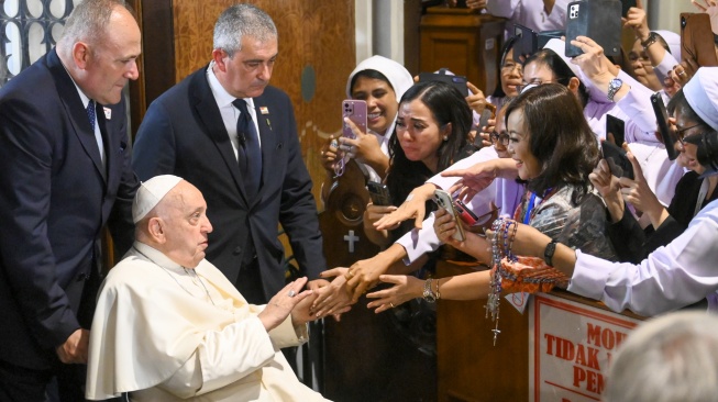 Paus Fransiskus berjabat tangan dengan umat Katolik setibanya di Gereja Katedral, Jakarta, Rabu (4/9/2024).  [ANTARA FOTO/Sulthony Hasanuddin/Ak/tom]