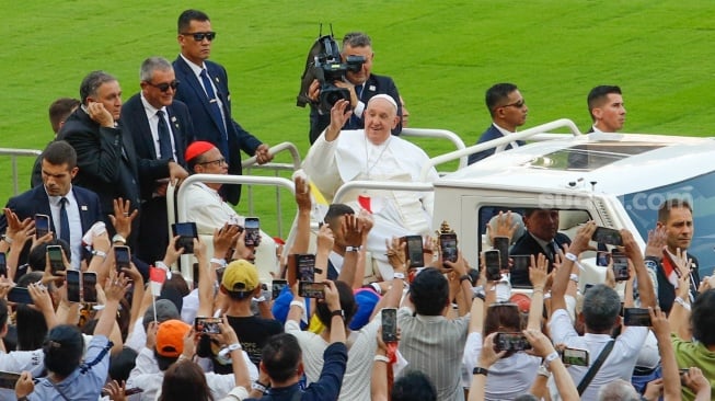 Pemimpin Takhta Suci Vatikan Paus Fransiskus menyapa umat Katolik sebelum mengikuti Misa di Stadion Utama Gelora Bilung Karno (GBK) Senayan, Jakarta, Kamis (5/9/2024). [Suara.com/Alfian Winanto]