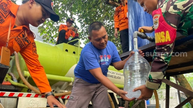 Warga Kota Tangsel mengisi galon menggunakan air bersih lantaran di wilayahnya terjadi kekeringan, Kamis (5/9/2024).