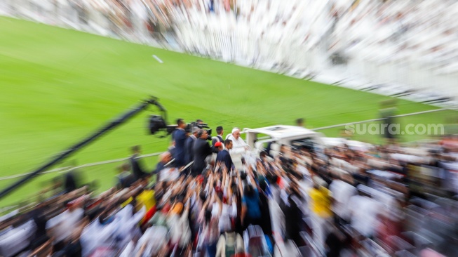 Pemimpin Takhta Suci Vatikan Paus Fransiskus menyapa umat Katolik sebelum mengikuti Misa di Stadion Utama Gelora Bilung Karno (GBK) Senayan, Jakarta, Kamis (5/9/2024). [Suara.com/Alfian Winanto]