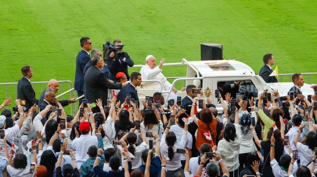 Pemimpin Takhta Suci Vatikan Paus Fransiskus menyapa umat Katolik sebelum mengikuti Misa di Stadion Utama Gelora Bilung Karno (GBK) Senayan, Jakarta, Kamis (5/9/2024). [Suara.com/Alfian Winanto]