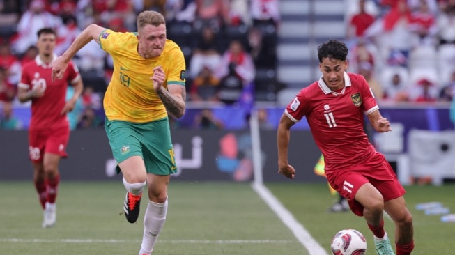 Penyerang Timnas Indonesia, Rafael Struick berlari membawa bola melewati bek Australia, Harry Souttar selama pertandingan Piala Asia 2023 antara Australia vs Indonesia di Stadion Jassim bin Hamad di Doha pada 28 Januari 2024.Giuseppe CACACE / AFP.