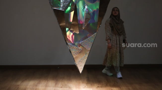 Pengunjung mengamati karya seni dalam pameran seni rupa "Infinity Yin Yang" karya Lini Natalini Widhiasi di Galeri Nasional, Jakarta, Minggu (8/9/2024). [Suara.com/Alfian Winanto]