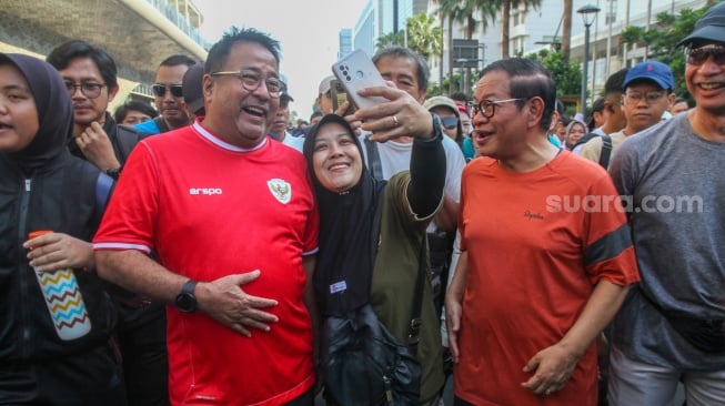 Pasangan bakal calon gubernur dan bakal calon wakil gubernur Pramono Anung dan Rano Karno berswafoto dengan warga saat CFD di Bundaran HI, Jakarta, Minggu (8/9/2024). [Suara.com/Alfian Winanto]