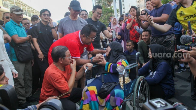 Pasangan bakal calon gubernur dan bakal calon wakil gubernur Pramono Anung dan Rano Karno menyapa warga saat CFD di Bundaran HI, Jakarta, Minggu (8/9/2024). [Suara.com/Alfian Winanto]