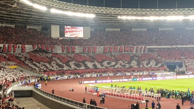 Kelompok suporter Timnas Indonesia, La Grande Indonesia (LGI), membuat koreografi bertuliskan "INDONESIA" disertai banner bedar bertuliskan "LET'S FIGHT FOR OUR DREAMS!!!" di tribun utara Stadion Utama Gelora Bung Karno (SUGBK). (Suara.com/Arief Apriadi)