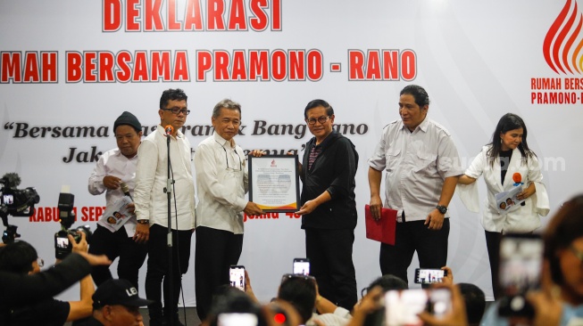 Relawan memberikan Plakat kepada Bakal Calon Gubernur Jakarta Pramono Anung saat Deklarasi Rumah Bersama Pramono-Rano di Gedung Joeang 45, Jakarta, Rabu (11/9/2024). [Suara.com/Alfian Winanto]