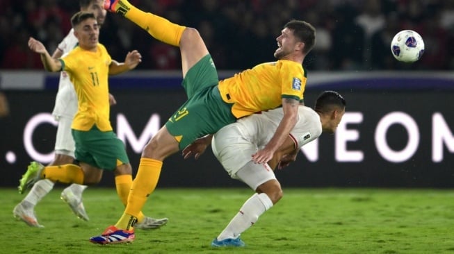 Cameron Burgess (tengah) dari Australia menyundul bola ke arah bek Timnas Indonesia Jay Idzes (kanan) selama pertandingan kualifikasi Piala Dunia  2026 antara Indonesia vs Australia di Stadion Gelora Bung Karno, Jakarta, pada 10 September 2024.BAY ISMOYO / AFP.