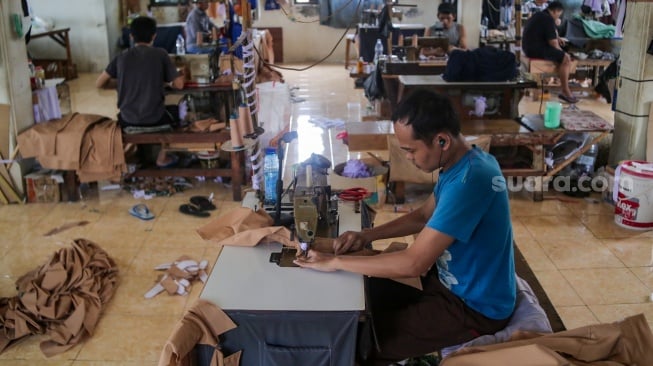 Pekerja menyelesaikan pembuatan seragam sekolah di rumah konveksi di Kawasan Mampang, Jakarta, Kamis (12/9/2024). [Suara.com/Alfian Winanto]