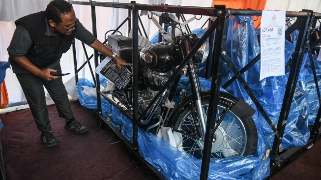 Petugas balai lelang memeriksa motor Royal Enfield yang dilelang di Tempat Penimbunan Pabean, Cilincing, Jakarta, Jumat (13/9/2024). [ANTARA FOTO/Hafidz Mubarak A/YU]