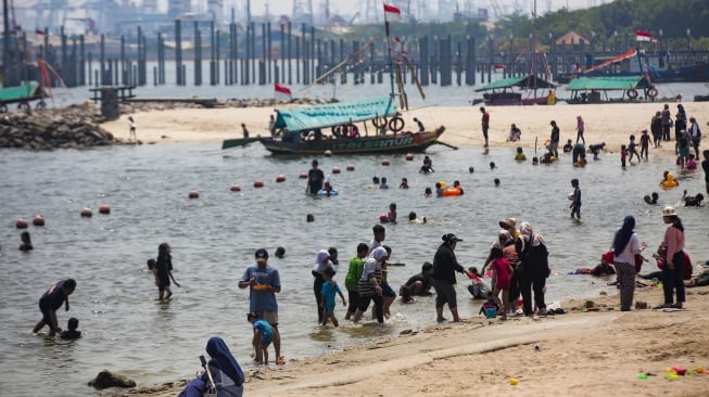 Pengunjung bermain air di Pantai Lagoon, Ancol Taman Impian, Jakarta, Senin (16/9/2024). [Suara.com/Alfian Winanto]