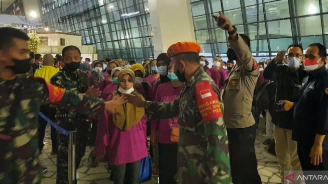 Ilustrasi - Petugas saat melakukan pengamanan kepada pekerja migran Indonesia yang tiba di Bandara Soetta (Azmi Samsul Maarif)
