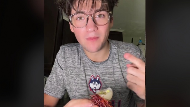 Bule makan buah dan biji rambutan. (TikTok/@hypieee)