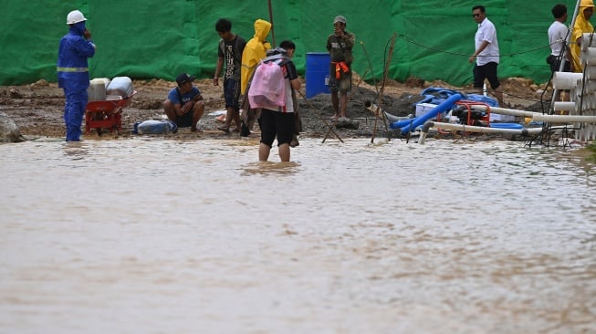 Pekerja memasang instalasi pompa air untuk menyedot air yang merendam area venue menembak PON XXI Aceh-Sumut 2024 yang tergenang air di Lapangan Tembak Rindam IM Mata Ie, Aceh Besar, Aceh, Selasa (17/9/2024). [ANTARA FOTO/Arnas Padda/aww]