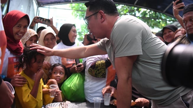 Bakal calon Gubernur DKI Jakarta Ridwan Kamil (kanan) berbincang dengan seorang anak saat meninjau posko makan gratis di Warakas, Jakarta, Jumat (20/9/2024). [ANTARA FOTO/Akbar Nugroho Gumay/foc]