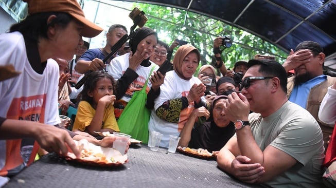 Bakal calon Gubernur DKI Jakarta Ridwan Kamil (kanan) berbincang dengan warga saat meninjau posko makan gratis di Warakas, Jakarta, Jumat (20/9/2024). [ANTARA FOTO/Akbar Nugroho Gumay/foc]
