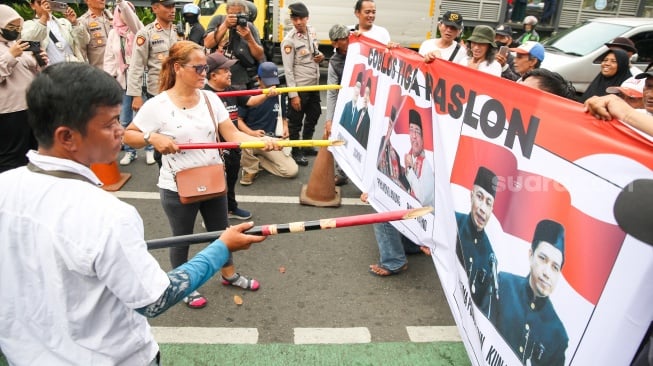 Massa dari Jaringan Rakyat Miskin Kota (JRMK) menggelar aksi demo di depan Kantor KPU Jakarta, Senin (23/9/2024). [Suara.com/Alfian Winanto]