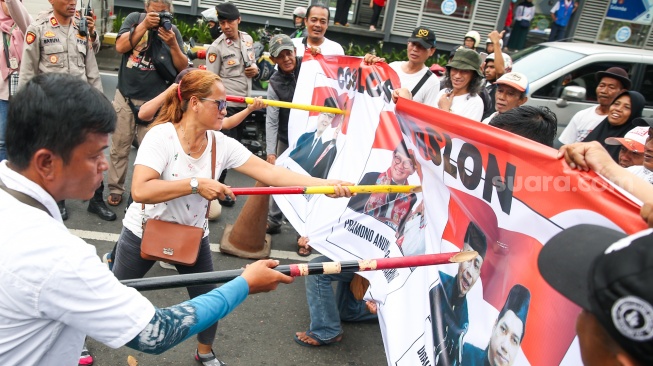 Massa dari Jaringan Rakyat Miskin Kota (JRMK) menggelar aksi demo di depan Kantor KPU Jakarta, Senin (23/9/2024). [Suara.com/Alfian Winanto]