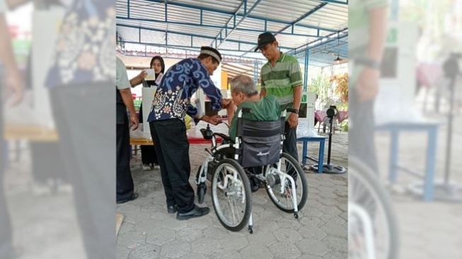 Ilustrasi pemilih disabilitas dibantu petugas TPS wilayah Sedayu, Bantul (Dok. SIGAB Indonesia)