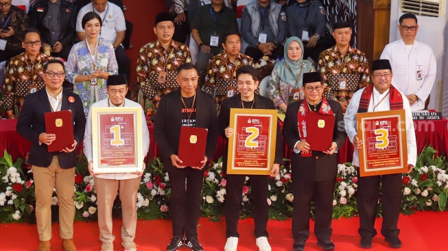 (dari kiri ke kanan) Pasangan Calon Gubernur dan Calon Wakil Gubernur Jakarta, Ridwan Kamil - Suswono, Dharma Pongrekun - Kun Wardana dan Pramono Anung - Rano Karno menunjukan nomer urut usai mengikuti rapat pleno terbuka pengundian nomor urut peserta calon pemilihan kepala daerah di KPUD Jakarta, Senin (23/9/2024). [Suara.com/Alfian Winanto]