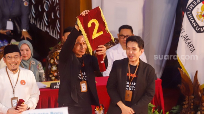 Pasangan Calon Gubernur dan Calon Wakil Gubernur Jakarta, Dharma Pongrekun - Kun Wardana menunjukan nomor saat mengikuti rapat pleno terbuka pengundian nomor urut peserta calon pemilihan kepala daerah di KPUD Jakarta, Senin (23/9/2024). [Suara.com/Alfian Winanto]