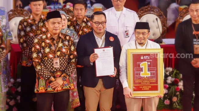 Pasangan Calon Gubernur dan Calon Wakil Gubernur Jakarta, Ridwan Kamil - Suswono menerima nomor urut saat mengikuti rapat pleno terbuka pengundian nomor urut peserta calon pemilihan kepala daerah di KPUD Jakarta, Senin (23/9/2024). [Suara.com/Alfian Winanto]