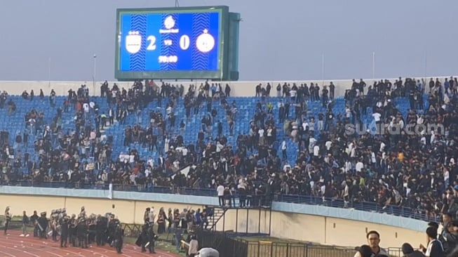 Pihak kepolisian mengamankan tribun selatan Stadion Si Jalak Harupat, Kabupaten Bandung, usai pertandingan Persib vs Persija. [Suara.com/Rahman]