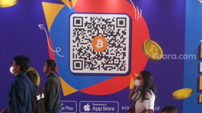 Warga melintas dengan latar iklan bitcoin di Terowongan Kendal, Jakarta, Selasa (24/9/2024). [Suara.com/Alfian Winanto]