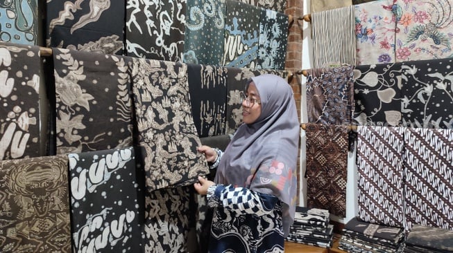 Ii Hurairoh menunjukkan berbagai produk unggulan Batik Akasia miliknya di rumah produksi yang berlokasi di Banguntapan, Bantul, Daerah Istimewa Yogyakarta (DIY), Rabu (11/9/2024). Batik Akasia merupakan salah satu Usaha Mikro Kecil Menengah (UMKM) yang dibina Astra melalui Yayasan Dharma Bhakti Astra (YDBA). (Suara.com/Rima Sekarani I.N.)