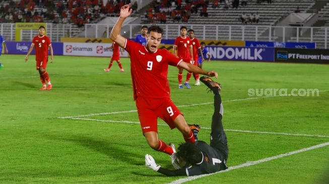 Pemain Timnas Indonesia U-20 Jens Raven beradu dengan kiper Timnas Maladewa U-20 Mohamed Yaameen dalam pertandingan kualifikasi Piala Asia U-20 2025 grup F di Stadion Madya, Jakarta, Rabu (25/9/2024). [Suara.com/Alfian Winanto]