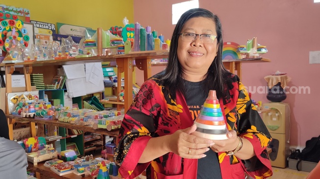 Pemilik ABC Woodentoys, Rita Indriana, menunjukkan produk mainan anak di showroom ABC Woodentoys yang berlokasi di Gendeng GK IV / 598 A, Baciro, Gondokusuman, Yogyakarta, Selasa (17/9/2024). (Suara.com/Rima Sekarani I.N.)