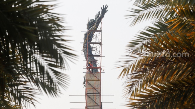 Petugas melakukan perawatan monumen Pembebasan Irian Barat di Lapangan Banteng, Jakarta Pusat, Kamis (26/9/2024). [Suara.com/Alfian Winanto]