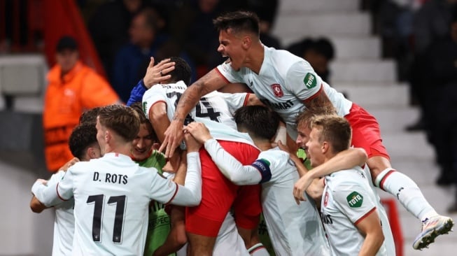 Bek keturunan Indonesia, Mees Hilgers (kanan atas) melakukan selebrasi bersama skuad FC Twente setelah timnya mencetak gol penyama kedudukan kontra Manchester United dalam matchday pertama Liga Europa 2024/2025 di Old Trafford, Kamis (26/9/2024) dini hari WIB. [Dok. AFP]