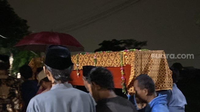 Jenazah Muhamad Farhan (20) satu dari 7 remaja tewas di Kali Bekasi, malam ini dimakamkan, Kamis (26/9/2024). Cuaca hujan mengiringi prosesi pemakaman korban. [Suara.com/Mae Harsa]