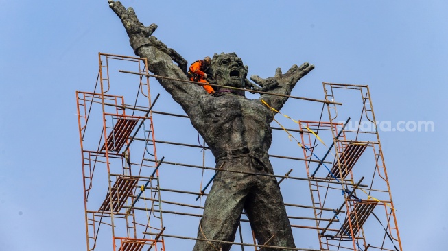 Petugas melakukan perawatan monumen Pembebasan Irian Barat di Lapangan Banteng, Jakarta Pusat, Kamis (26/9/2024). [Suara.com/Alfian Winanto]