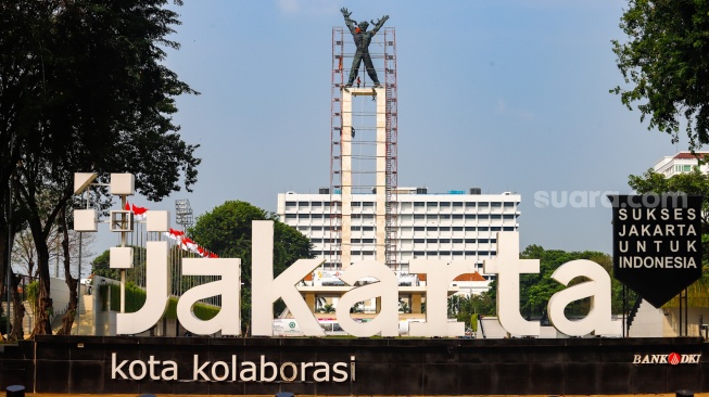 Petugas melakukan perawatan monumen Pembebasan Irian Barat di Lapangan Banteng, Jakarta Pusat, Kamis (26/9/2024). [Suara.com/Alfian Winanto]