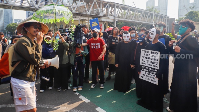 Aktivis lingkungan melakukan aksi di Jalan Sudirman, Jakarta, Jumat (27/9/2024). [Suara.com/Alfian Winanto]