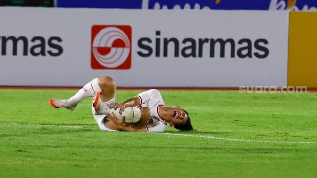 Pemain Timnas Indonesia U-20 Arlyansyah Abdulmanan mengerang kesakitan usai dilanggar pemain Timnas Timor Leste U-20 dalam pertandingan kualifikasi Piala Asia U-20 grup F di Stadion Madya, Jakarta, Jumat (27/9/2024). [Suara.com/Alfian Winanto]