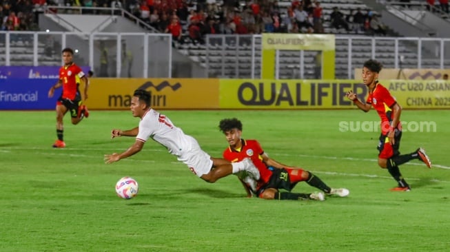 Pemain Timnas Indonesia U-20 Tony Firmansyah terjatuh usai dilanggar pemain Timnas Timor Leste U-20 dalam pertandingan kualifikasi Piala Asia U-20 grup F di Stadion Madya, Jakarta, Jumat (27/9/2024). [Suara.com/Alfian Winanto]