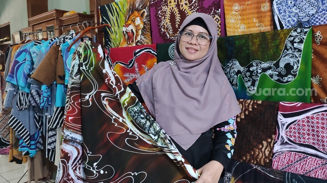 Evi Rosalina Widyayanti menunjukkan sejumlah produk unggulan Batik Namburan di rumah produksi yang berlokasi di Wirobrajan, Yogyakarta, Selasa (3/9/2024). Batik Namburan merupakan salah satu Usaha Mikro Kecil Menengah (UMKM) yang dibina Astra melalui Yayasan Dharma Bhakti Astra (YDBA). (Suara.com/Rima Sekarani I.N.)