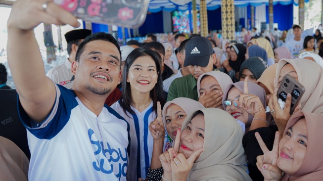 Bobby Nasution dan istri Kahiyang Ayu selfie bersama masyarakat di Tapsel. [Ist]