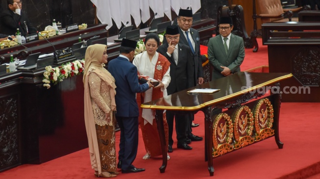 Anggota DPR periode 2024-2029 tertua dari Partai Demokrat Zulfikar Achmad (kedua kiri) didampingi anggota DPR termuda dari Partai Gerindra Annisa MA Mahesa (kiri) menerima berkas Memori DPR dari Ketua DPR periode 2019-2024 Puan Maharani (ketiga kiri) bersama jajaran Wakil Ketua DPR periode 2019-2024 Sufmi Dasco Ahmad (ketiga kanan), Rachmat Gobel (kedua kanan) dan Muhaimin Iskandar (kanan) dalam rapat paripurna perdana di Gedung Nusantara, Kompleks Parlemen, Senayan, Jakarta, Selasa (1/10/2024). [Suara.com/Alfian Winanto]