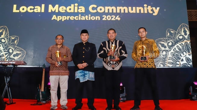 CFO PT Arkadia Digital Media, Fastabiqul Khair Algatot (kedua kiri) foto bersama para penerima penghargaan Kategori Pemerintahan Pendukung Media Lokal dalam sesi Appreciation Night di acara Local Media Summit 2024 di Hotel Sultan, Jakarta, Rabu (2/10/2024). [Suara.com/Alfian Winanto]