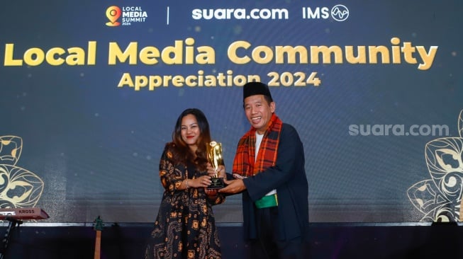 Pemimpin Redakai Suara.com Suwarjono (kanan) memberikan piagam penghargaan kepada perwakilan Bank Rakyat Indonesia (BRI) dalam sesi Appreciation Night di acara Local Media Summit 2024 di Hotel Sultan, Jakarta, Rabu (2/10/2024). [Suara.com/Alfian Winanto]