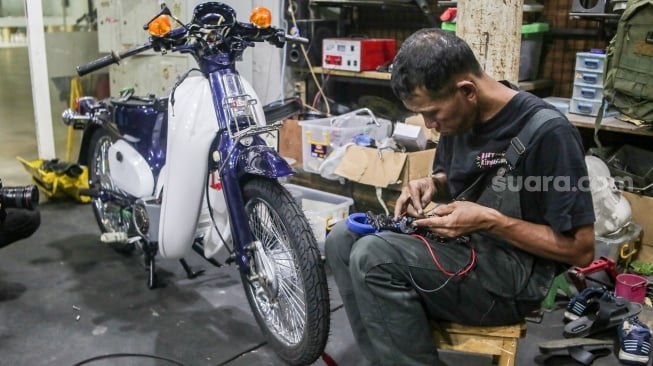 Teknisi mengonversi sepeda motor berbahan bakar minyak menjadi sepeda motor listrik di Bengkel Elders Garage, Jakarta, Jumat (4/10/2024). [Suara.com/Alfian Winanto]