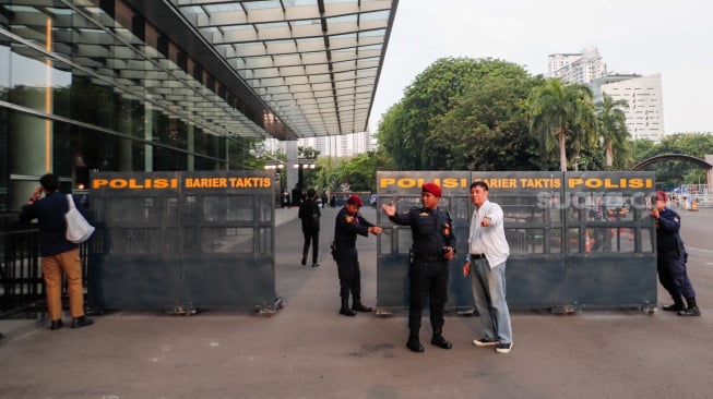 Petugas keamanan memasang barier di luar lokasi Debat Pilgub Jakarta 2024 di JIExpo Kemayoran, Jakarta, Minggu (6/10/2024). [Suara.com/Alfian Winanto]