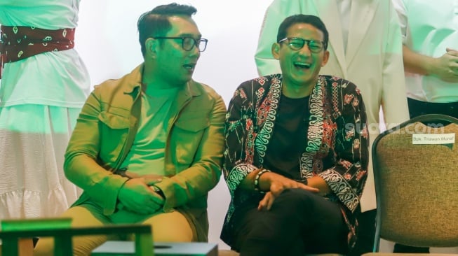 Menteri Parekraf Sandiaga Uno (kanan) dan Calon Gubernur Jakarta Ridwan Kamil (kiri) bersalaman  saat bertemu di pameran Indonesian Contemporary Art and Design ke-14: Unexpected di Hotel Grandkemang, Jakarta, Rabu (9/10/2024). [Suara.com/Alfian Winanto]