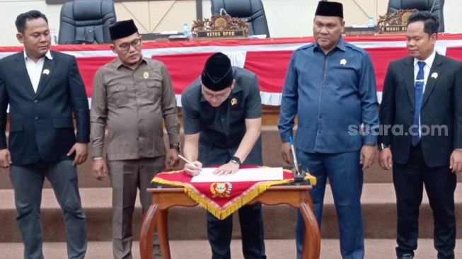 Ketua DPRD Cilegon, Rizki Khairul Ichwan menandatangani surat keputusan penentuan unsur pimpinan Badan Kehormatan (BK). [Hairul Alwan/Suara.com]