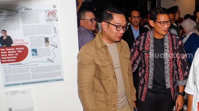 Menteri Parekraf Sandiaga Uno (kanan) dan Calon Gubernur Jakarta Ridwan Kamil (kiri) saat bertemu di pameran Indonesian Contemporary Art and Design ke-14: Unexpected di Hotel Grandkemang, Jakarta, Rabu (9/10/2024). [Suara.com/Alfian Winanto]